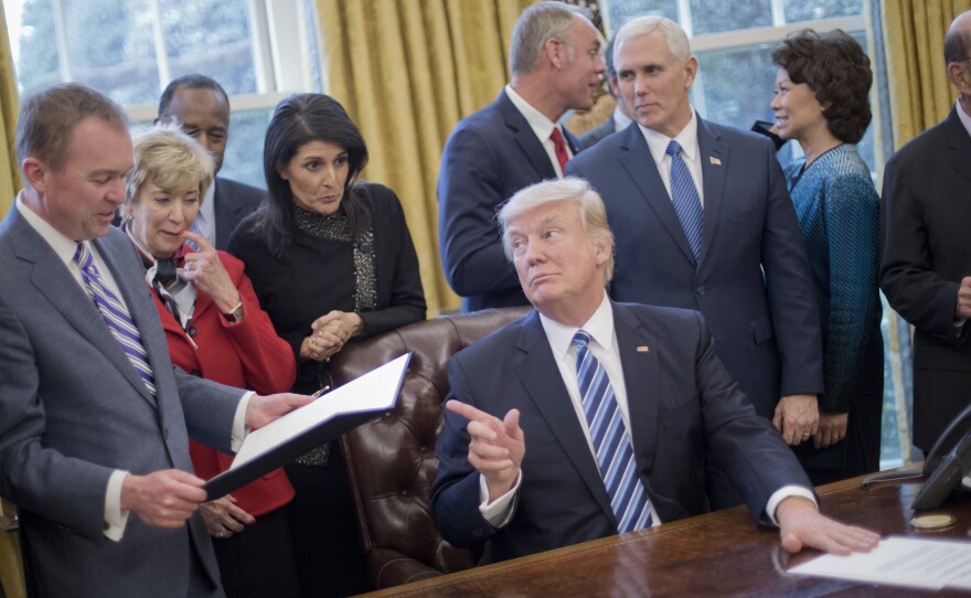 President Donald Trump looks over towards Budget Director Mick Mulvaney, left, after signing his "Comprehensive Plan for Reorganizing the Executive Branch" executive order.
