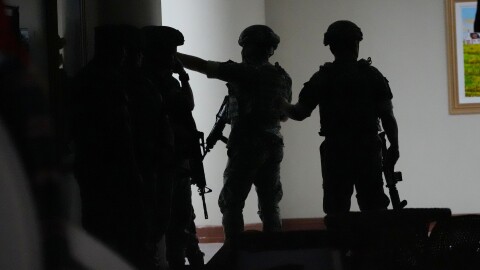 Philippine troopers exchange fire along a hallway at the Philippine Senate in Pasay, Philippines on Wednesday May 13.