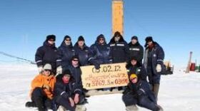 In Antarctica, Russian scientists posed at the site where they say they've drilled through to Lake Vostok. The sign indicates that the breakthrough happened on Feb. 5, 2012.