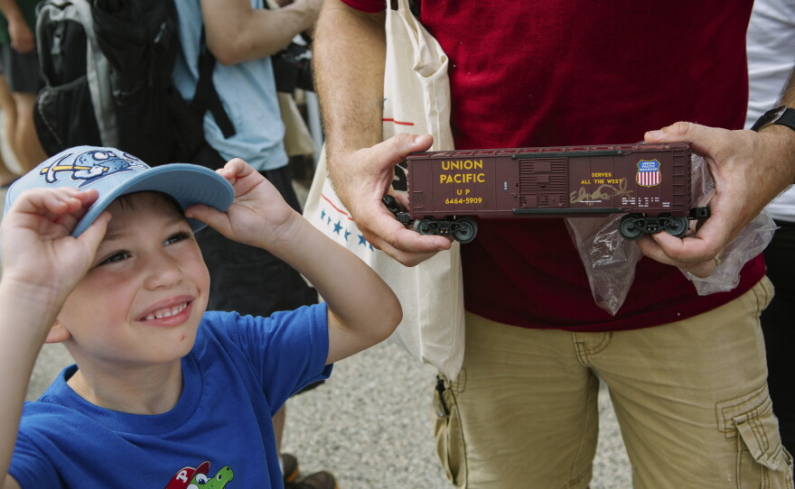 Joe Stefankiewicz, 37, of Aston, Pennsylvania, holds a signed model train car for his son, Joey, 5, in front of Union Pacific's Big Boy No. 4014, the world's largest operating steam engine locomotive, during a stop in Philadelphia.