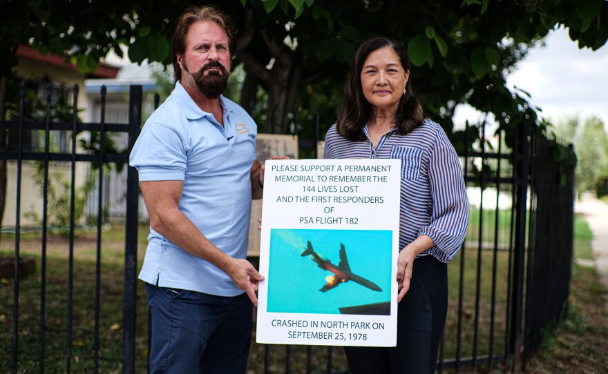 Mike Bagnas and Myra Sulit Pelowski are shown holding a poster board calling on people to support a proper memorial to the victims of PSA Flight 182 on Sept. 19, 2023.