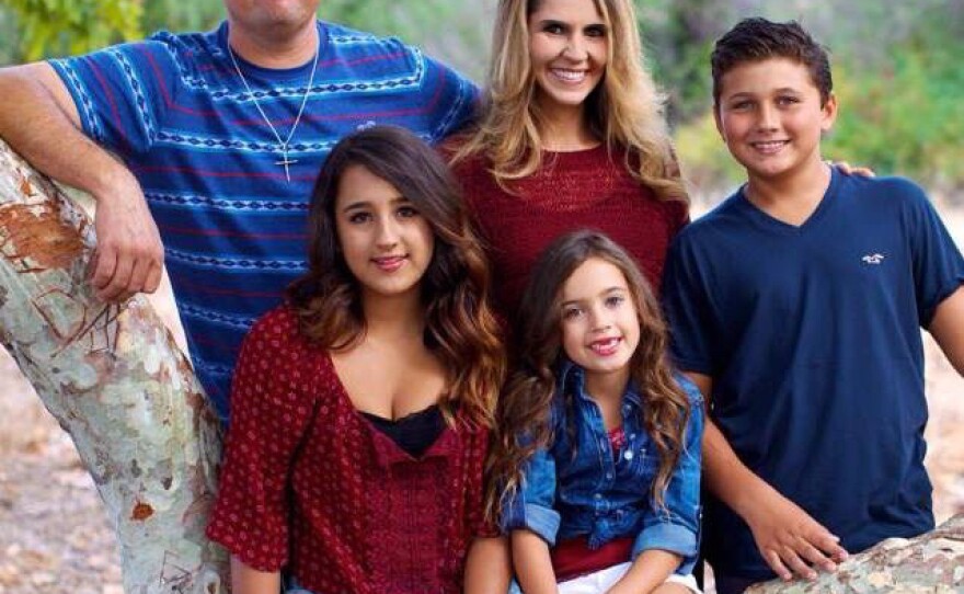 Heron and Michelle Moriarty pose with their three children in a photo taken before his death.