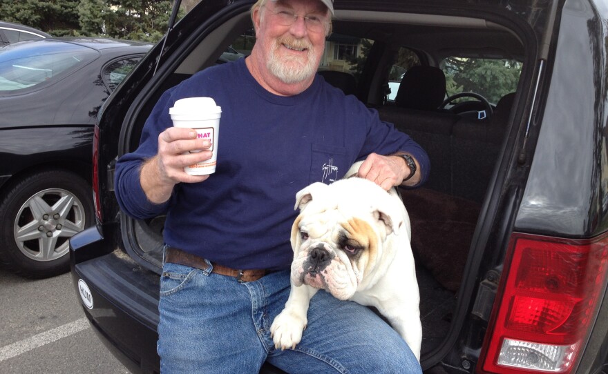 Mike Cragin and his bulldog, Truman, stopped by the Dunkin Donuts in Newtown, Conn., on Thursday. After the elementary school shooting in December, Cragin came to the same place and put up a sign inviting people to hug his dog.