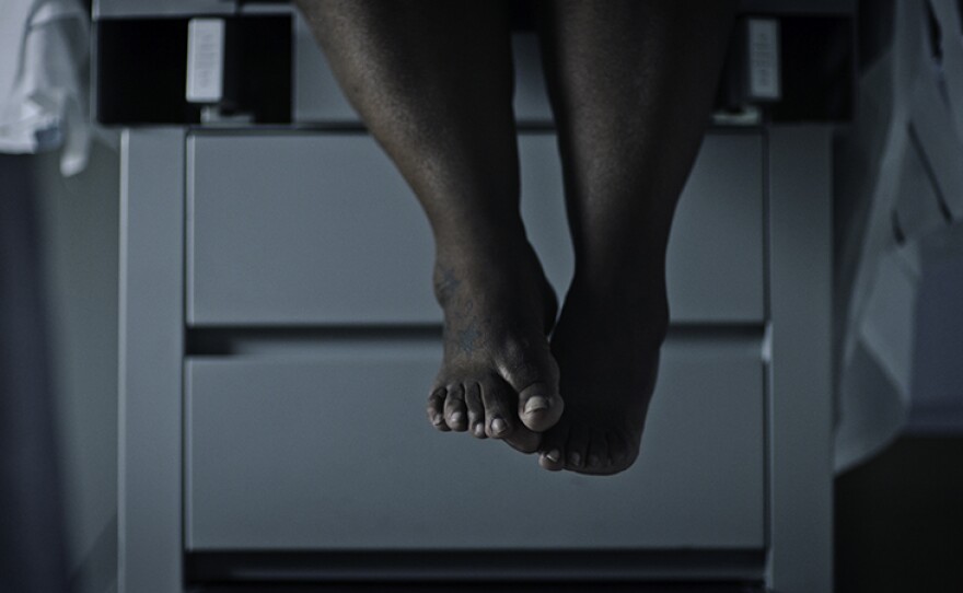 Woman’s feet dangling off the edge of an exam table