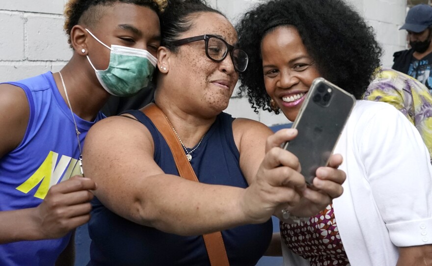 Acting Mayor Kim Janey, right, takes a photo as Bostonians gather together on Friday in Nubian Square. Janey is the first woman and first Black person to serve as mayor of Boston.