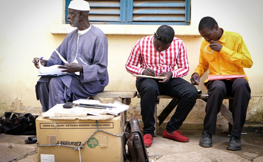 Getting postcards from Timbuktu, Mali, to destinations around the world is a lengthy process. Daba Traoré, center, takes the postcards — which have been flown in from Timbuktu on a U.N. plane — to the central post office in Bamako.