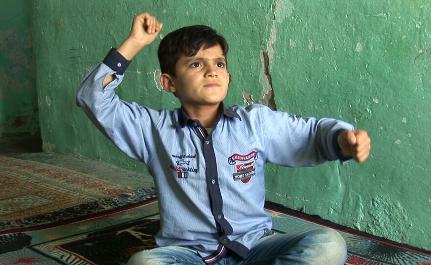 A boy describes the bombing of his village in Erkan Özgen's 2016 video <em>Wonderland.</em>