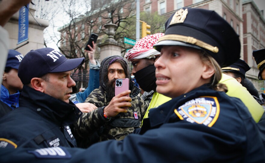 NYPD officers detain a person as pro-Palestinian protesters gather outside of Columbia University in New York City on Thursday. Officers cleared out a pro-Palestinian campus demonstration, a day after university officials testified about anti-Semitism before Congress.