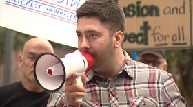 Jabez Lebret of Together We Will San Diego addresses people assembled outside U.S. Sen. Dianne Feinstein's office in downtown San Diego, Feb. 7, 2017. 