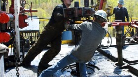 Workers move a section of well casting at a natural gas well site in Pennsylvania. Energy expert Daniel Yergin says that in addition to trucks and traffic, natural gas production can bring jobs and economic growth to gas-rich areas.