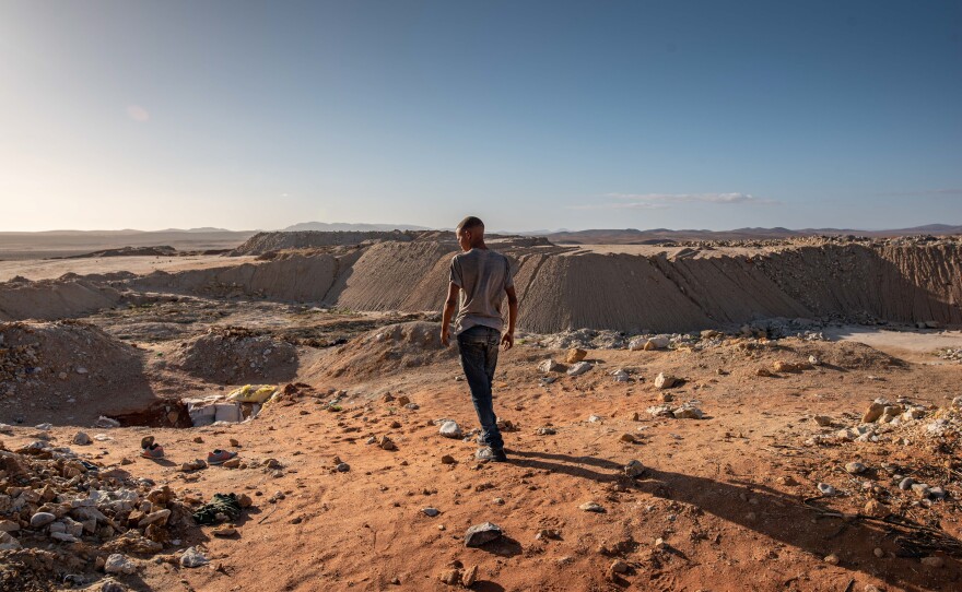 An illegal diamond miner looks out from the top of a De Beers mine that has since been taken over by zama-zamas.