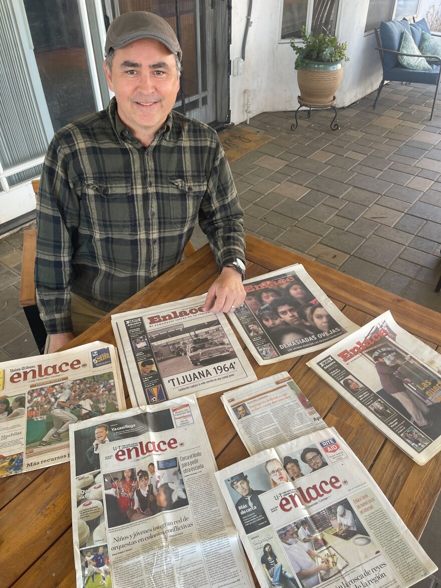 Former San Diego Union Tribune Spanish-language edition reporter and columnist Hiram Soto poses with various iterations of the weekly, which was cancelled last month.