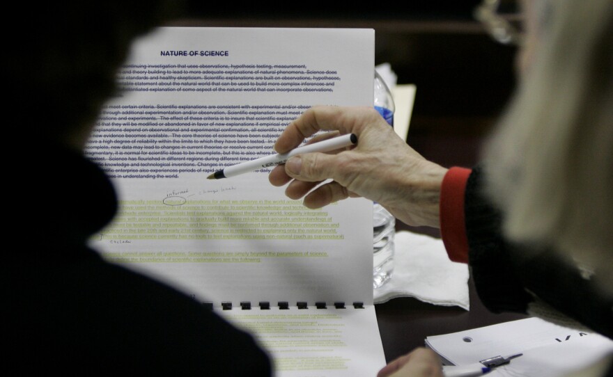 Kansas Board of Education members look over language for a science textbook in 2007. The fight over the teaching of evolution has been particularly fierce in Texas, which because of its size influences many textbook publishers.