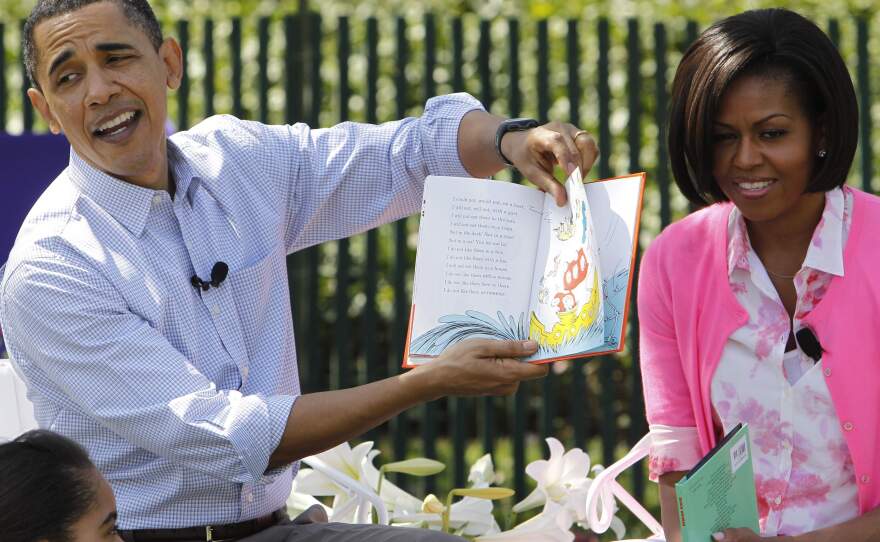 President Obama, accompanied by first lady Michelle Obama, reads