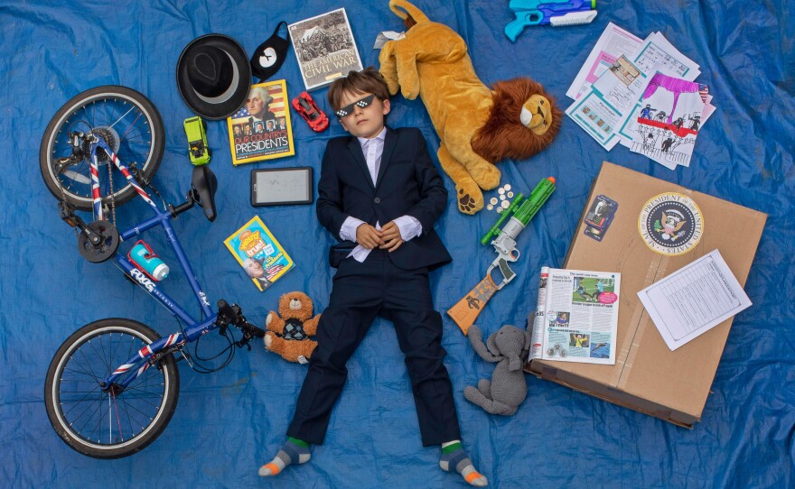 Ben, 10, lays next to his favorite objects, toys and books as part of a homeschooling assignment to create a time capsule to remind them of this time.