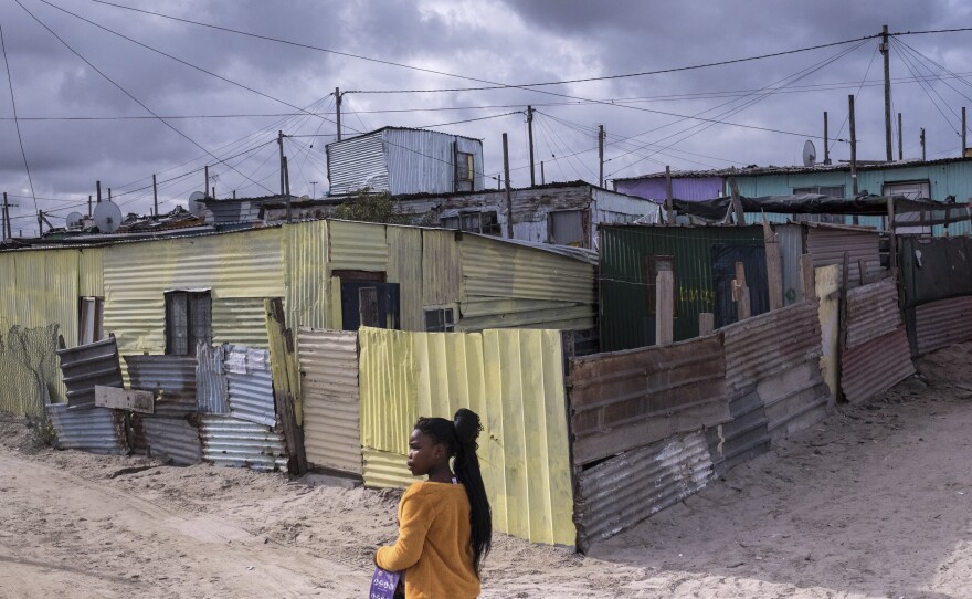 A girl walks past shacks in the township of Khayelitsha, Cape Town, South Africa. There are fears that it will be hard to control the spread of the coronavirus if it takes hold in the densely populated township, where dozens of people share a single communal toilet and families often share a single room.