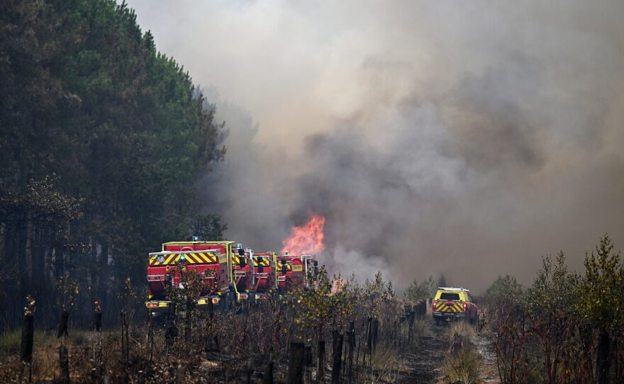 Firefighters tackle a blaze as wildfires rage near Le Las, outside Bordeaux, France, Monday, July 27, 2026.