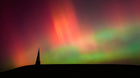 FILE - Northern lights fill the sky behind the Saint Joseph the Woodworker Shrine, near Valley Falls, Kan., Nov. 11, 2025.
