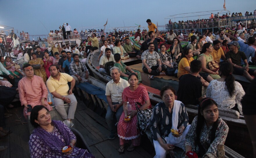 Worshippers and tourists sit on boats facing the bank of the Ganges River in the holy Hindu city of Varanasi to watch the Ganga Aarti, a ritual of devotion to the venerated river.