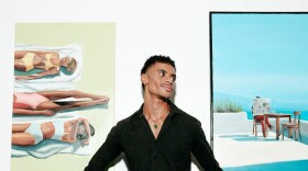 Fredo poses in front of a few of his pieces at his first solo show in San Diego Made Factory on Sept. 28, 2025.