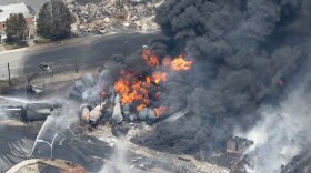 Smoke rises from railway cars that were carrying crude oil after derailing in downtown Lac Megantic, Quebec, Canada, July 6, 2013.