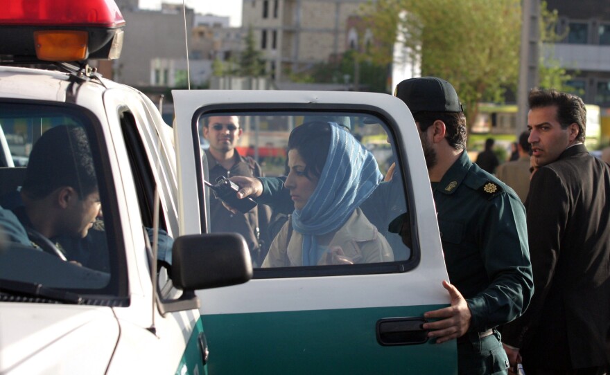 Police in Tehran detain a woman in 2007, for not adhering to the Islamic dress code.