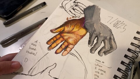 An Little Fish student shows off a page from their sketch book on July 21, 2025.