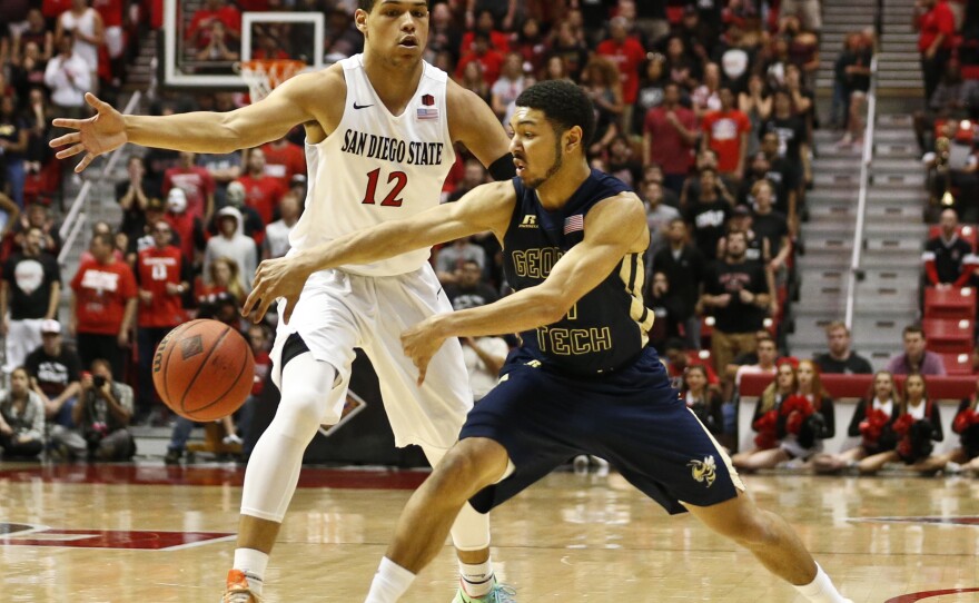 Georgia Tech guard Josh Heath throws a pass past San Diego State guard Trey Kell during the first half of an NCAA college basketball game in the men's NIT in San Diego, March 23, 2016.