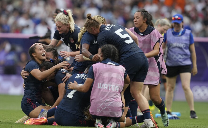 The United States team including United States' Alex Sedrick, left, celebrate after winning the women's bronze medal Rugby Sevens match between the United States and Australia at the 2024 Summer Olympics, in the Stade de France, in Saint-Denis, France, Tuesday, July 30, 2024. The US won the game 14-12.