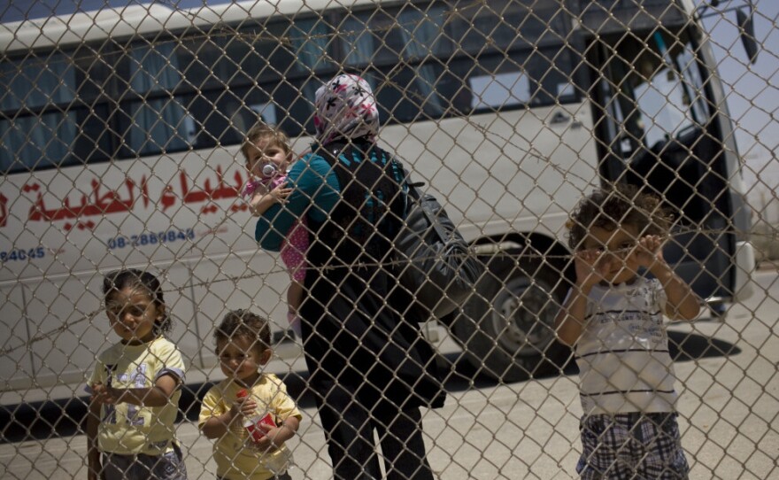 A Palestinian family waits to cross from the Gaza Strip into Egypt through the Rafah border crossing on Saturday.