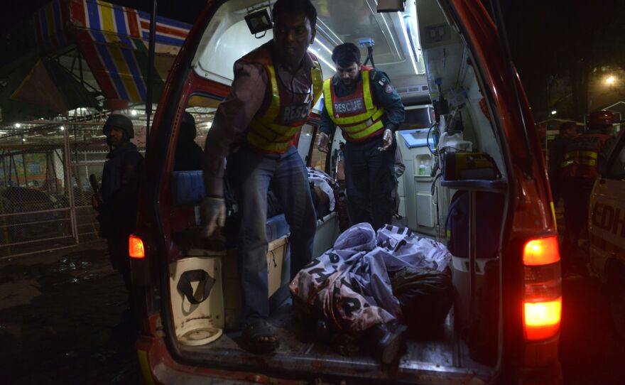 Rescuers carry a body in an ambulance from the bomb blast site.