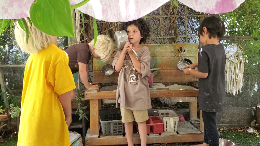 Kids play in the outdoor kitchen at Liberty Winn's childcare center in Carlsbad, May 18, 2022.