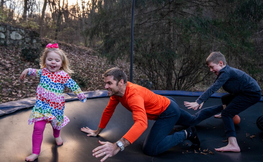 Blake Farmer plays with his kids, Louisa, 2, and Turner, 8, on the trampoline in their backyard in Nashville, Tennessee. After Thanksgiving, the family all had breakthrough COVID cases, resulting in a couple weeks spent at home. The trampoline served as a distraction for the kids, says Blake Farmer, their father.