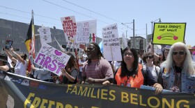 Demonstrators hold signs as they participate in the "Families Belong Together: Freedom for Immigrants" march on Saturday, June 30, 2018, in Los Angeles. 
