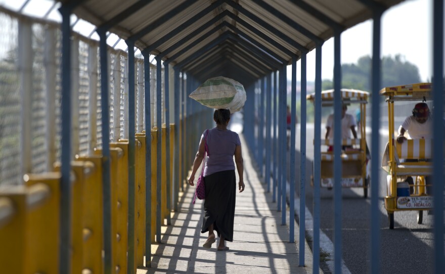 A woman walks on a Suchiate River bridge connecting Guatemala and Mexico. A State Department program allows some immigrants to bring their children to the U.S. from Honduras, El Salvador and Guatemala.