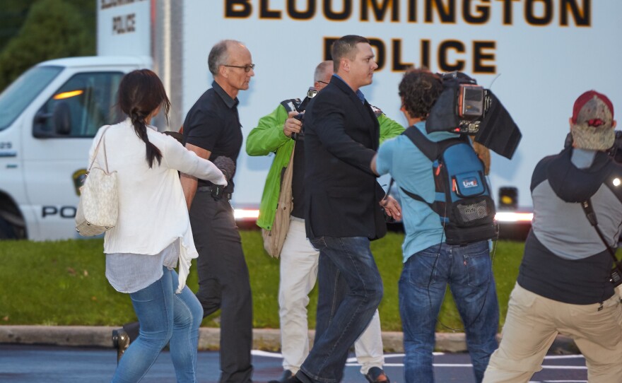 Dentist Walter Palmer (left, in short sleeves) walks into his clinic with private security and members of the media last month in Bloomington, Minn. Protests over his killing of a lion in Zimbabwe had forced him to temporarily close his practice. Now officials say they will not prosecute him.