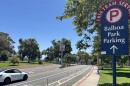A car drives past a sign directing traffic to Balboa Park's parking lots and free tram service, July 28, 2025.