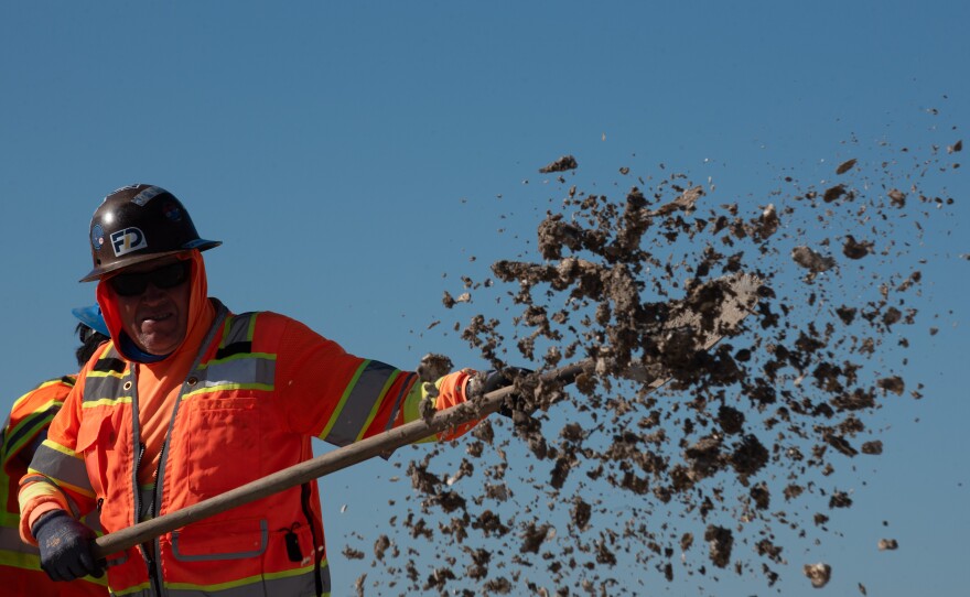 A SANDAG construction worker spreading crushed oyster shells during a restoration project at the nesting site for the California least terns at Batiquitos Lagoon, Dec. 9, 2025.