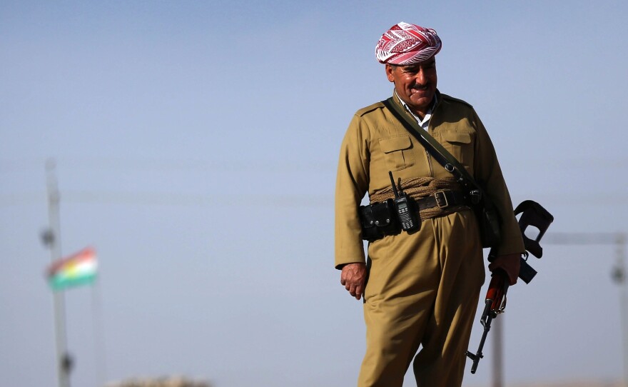 An Iraqi Kurdish Peshmerga fighter stands on a berm 25 miles south of Erbil, the capital of the Kurdish region in northern Iraq, on Oct. 5. Turkish Kurds have been joining the Iraqi Kurds in the fight against the Islamic State.