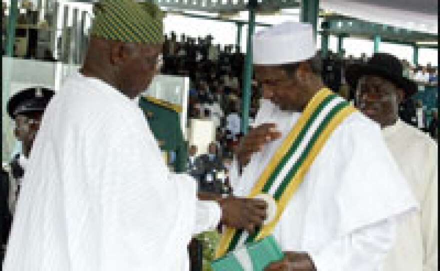Former Nigerian President Olusegun Obasanjo decorates his successor Umaru Yar'Adua during a swearing-in ceremony for the new president at Eagles Square in Abuja on May 29.