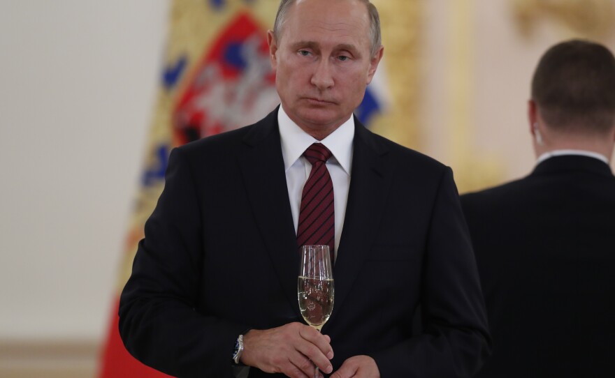 Russian President Vladimir Putin holds a glass of Soviet Champagne during a Kremlin ceremony in 2017. A new Russian law says only Russian sparkling wine may be sold in Russia as "champagne."