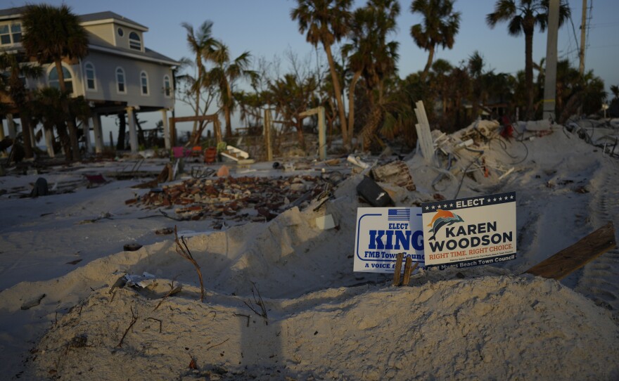 Signs promoting candidates for Fort Myers Beach town council sit along a roadside on Estero Island, which was heavily damaged in September's Hurricane Ian, in Fort Myers Beach, Fla., on Tuesday.