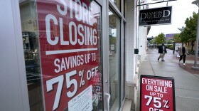 In this Wednesday, Sept. 2, 2020, file photo, passers-by walk past a business storefront with store closing and sale signs in Dedham, Mass. U.S. employers advertised for slightly fewer jobs in August while their hiring ticked up modestly. 