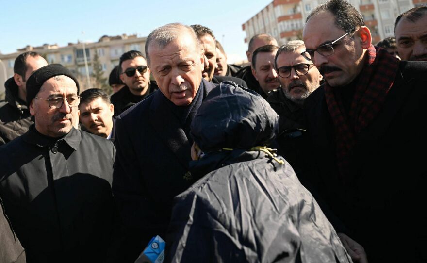 Turkish President Recep Tayyip Erdogan (center) meets with residents who have been affected by the earthquake and are staying in tents set up by the government in Kahramanmaras.