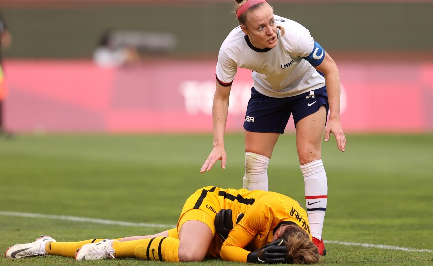 U.S. goalkeeper Alyssa Naeher lies injured as Becky Sauerbrunn checks on her during the Women's semifinal match between USA and Canada on Monday at the Tokyo Olympic Games at Kashima Stadium.
