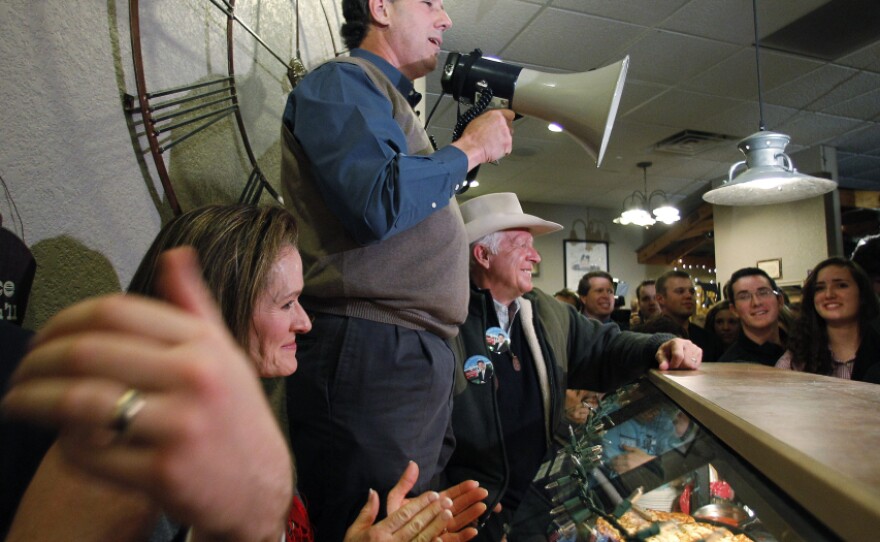 Former Pennsylvania Sen. Rick Santorum, who has recently surged in the Iowa polls, used a bullhorn during a meet-and-greet campaign stop Monday at the Pizza Ranch in Altoona, Iowa.