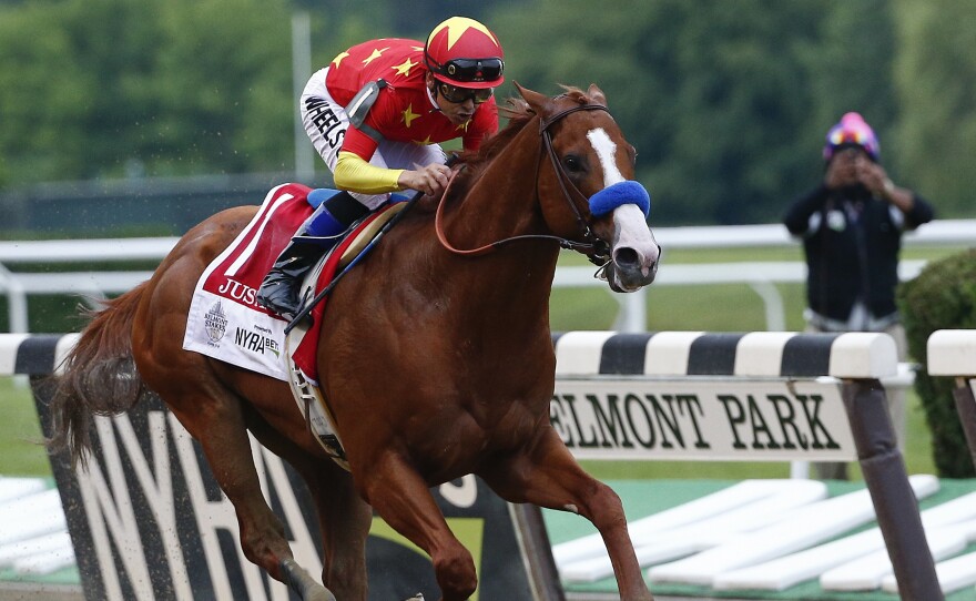 Justify, with jockey Mike Smith aboard, crosses the finish line to win the 150th running of the Belmont Stakes horse race, and the rare Triple Crown title on Saturday in Elmont, N.Y.