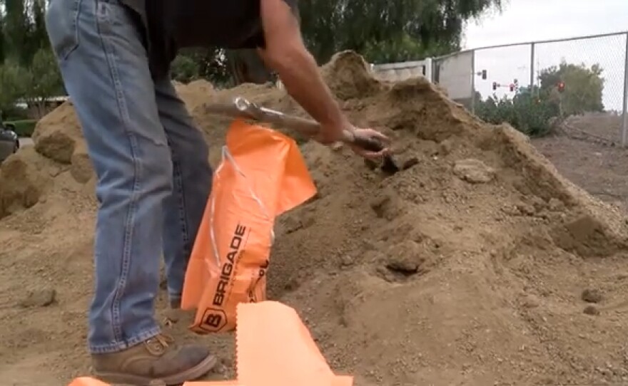 Dan Weber shoveling sand into sandbags provided by San Diego County ahead of a winter storm heading into the area, Dec. 13, 2021.