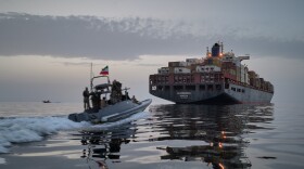 A Revolutionary Guard Navy (IRGC) speedboat approaches the cargo ship Epaminondas during what state media described as the seizure of one of two vessels accused of violations in the Strait of Hormuz, April 21, 2026.