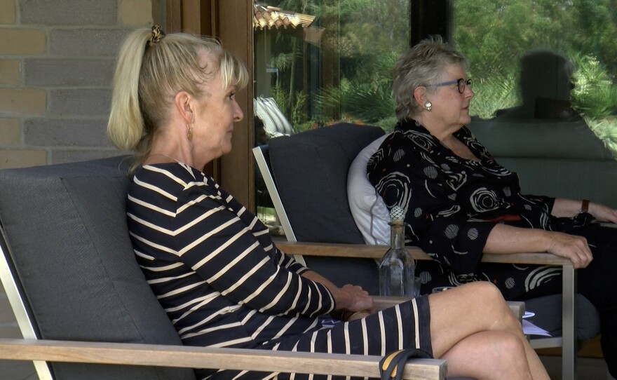Janet Lawless-Christ (left) and Mary Bills sit and talk in Bill's garden, August 11, 2021.